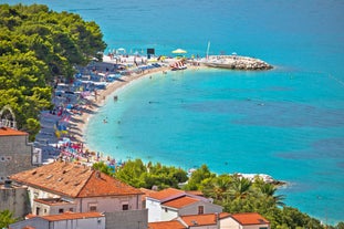 Photo of panorama and landscape of Makarska resort and its harbour with boats and blue sea water, Croatia.