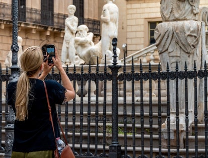 photo of Photo of a tourist taking pictures of the beautiful Fontana Pretoria also known as the square of shame for its nude statues in the heart of Palermo .