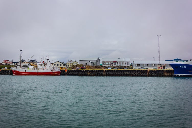 photo of view of Harbor with boats and buildings with cloudy sky, Höfn, Southeast Iceland.