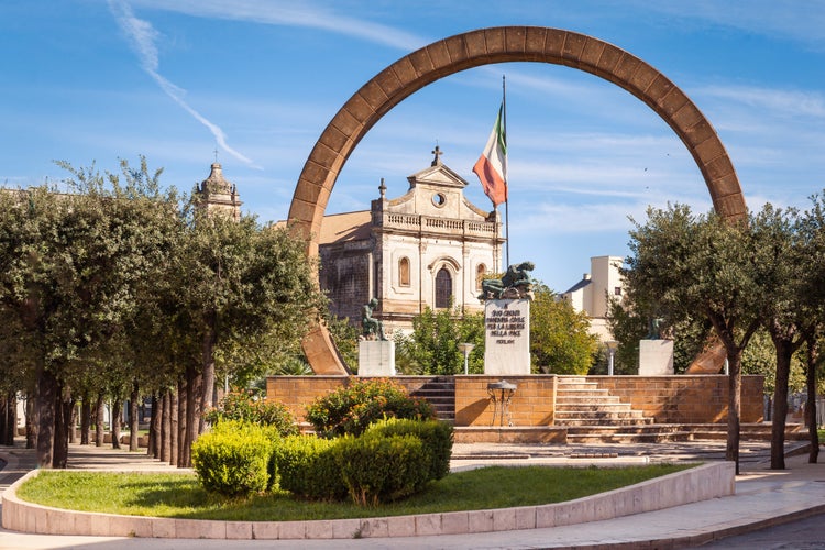 View of the village of Manduria, Lecce, Italy with the monument to the fallen and the Church of St. Francis (San Francesco). Transl.:"To our fallens civil Manduria for freedom in peace 1966"