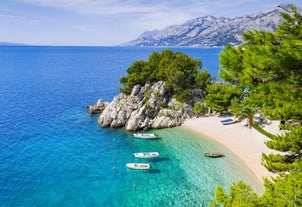 Photo of panorama and landscape of Makarska resort and its harbour with boats and blue sea water, Croatia.