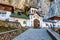 Photo of Ialomiței Cave with Saints Peter and Paul Church at the entrance. An orthodox Monastery built in a cave in Bucegi Mountains, Carpathians, Romania.