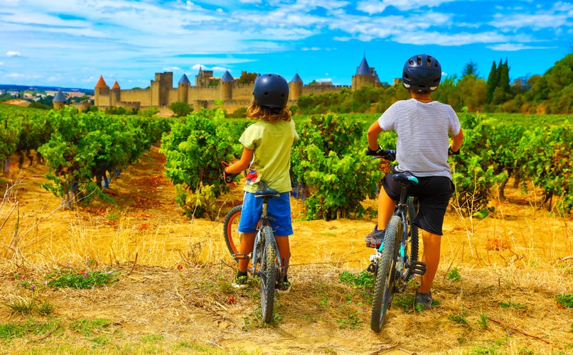 Photo of two children looking at beautiful castle of Carcassonne in France.