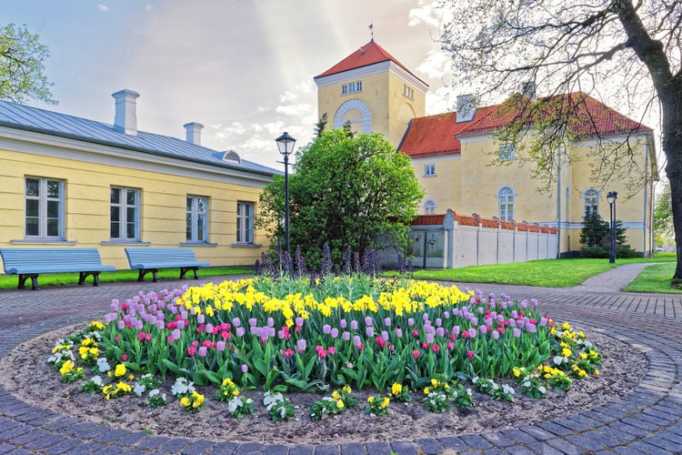 Photo of Ventspils Castle and tulips in the flowerbed in the Old toen in Latvia. The Castle was built by the Livonian Order. It is the oldest castle built by the Livonian Order.