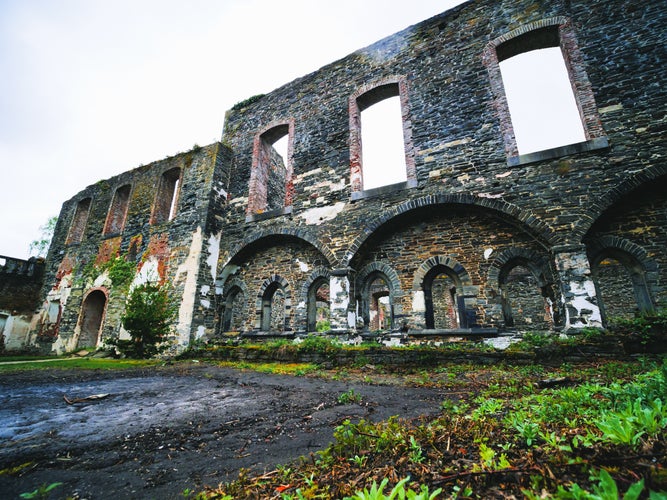 photo of view of Ancient Stone Ruins Archways, Historical, Lush Greenery at Villers-la-Ville Abbey, Belgium