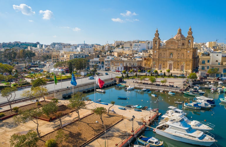 Photo of Aerial view of Msida marina bay and church. Sunny day, Maltese and Europe flags. Malta island.