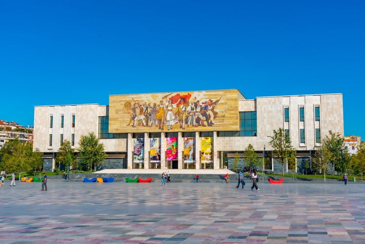 People are strolling in front of the National History museum in Tirana, Albania