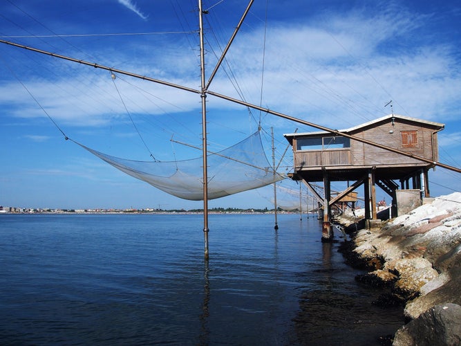 Photo of fishing station on the dam of Sottomarina with beautiful blue water, Chioggia, in Italy.