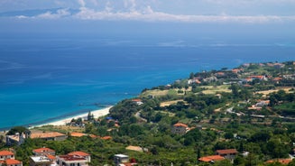 photo of an aerial view of Parghelia in Italy. Overview of seabed seen from above, transparent water and beach with umbrellas.