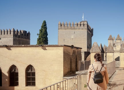 photo of a rear view of a young traveler lady at the Almodovar del Rio castle in Cordoba, Spain.
