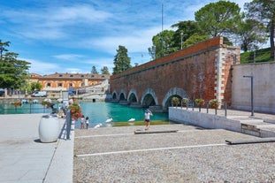 Photo of aerial view of Verona historical city centre, Ponte Pietra bridge across Adige river, Verona Cathedral, Duomo di Verona, red tiled roofs, Veneto Region, Italy.