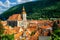 Photo of Brasov cityscape with black cathedral and mountain on backround in Romania .