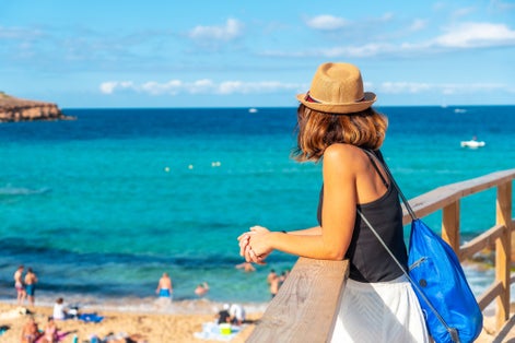 Photo of a tourist enjoying the peace at Cala Comte beach on the island of Ibiza.