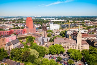 Cologne Aerial view with trains move on a bridge over the Rhine River on which cargo barges and passenger ships ply. Majestic Cologne Cathedral in the background.