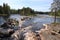 Photo of beautiful river scenery with cliffs, forest and rapids in Koitelinkoski in Oulu, Finland.