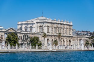 Touristic sightseeing ships in Golden Horn bay of Istanbul and mosque with Sultanahmet district against blue sky and clouds. Istanbul, Turkey during sunny summer day.