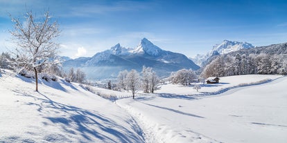 photo of Elevated, scenic view of the town of Bischofswiesen, Bavaria, Germany. The Watzmann Mountain, part of the Bavarian Alps rises into a majestic skyline. A green, spring landscape set in the valley.