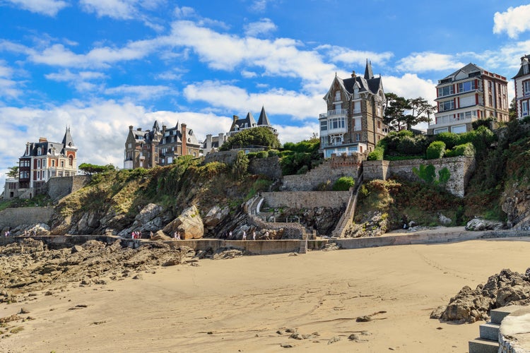 a pedestrian path along the coast (Ronde de la Malouin), a beach and villas at Cape Malouin at low tide.