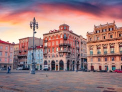 Photo of Italy Piazza Maggiore in Bologna old town tower of town hall with big clock and blue sky on background, antique buildings terracotta galleries.