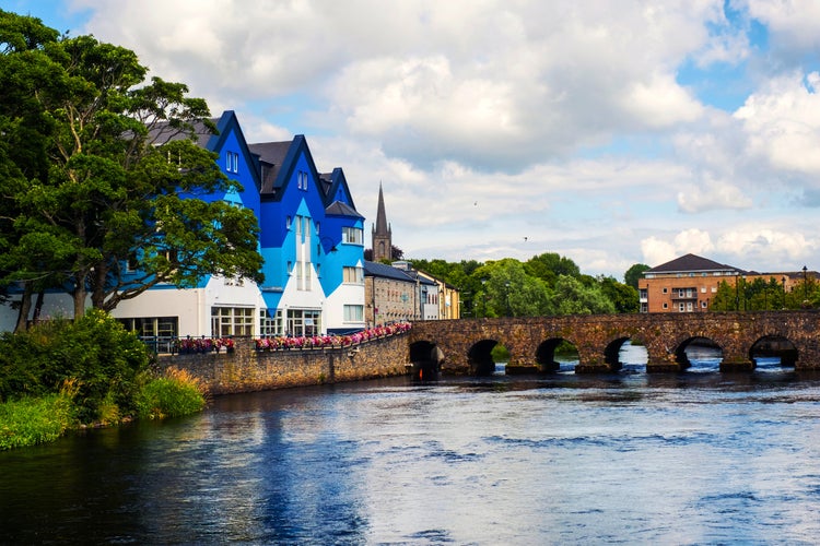 photo of view of Sligo, Ireland. Beautiful landscape in Sligo, Ireland with river and colorful houses. Cloudy sky in summer, old bridge over the river