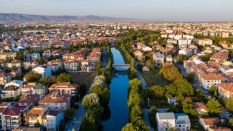 Photo of scenic aerial view of residential districts of Turkish city of Kutahya on background of hill with ruined Byzantine castle on top.