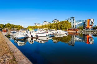 Photo of Vannes, beautiful city in Brittany, boats in the harbor, with typical houses and the cathedral in background, France.