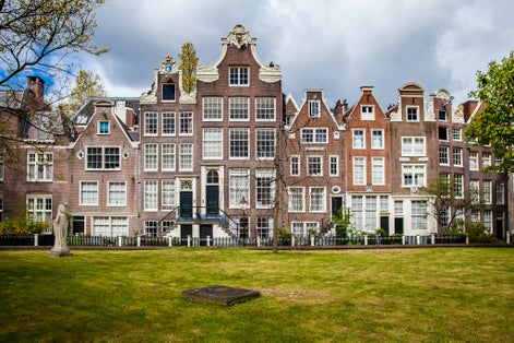 photo of famous facades, houses and garden in The Begijnhof is one of the oldest inner courts in the city of Amsterdam, the Netherlands.