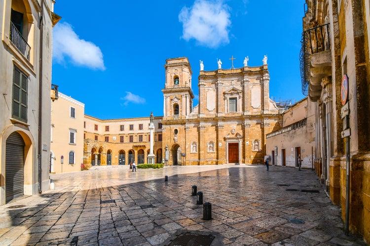 Morning as tourists begin to explore the Brindisi Duomo Cathedral and Bell tower in the Piazza Duomo in Brindisi, Italy, part of the southern Puglia region.