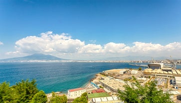 Naples, Italy. View of the Gulf of Naples from the Posillipo hill with Mount Vesuvius far in the background and some pine trees in foreground.