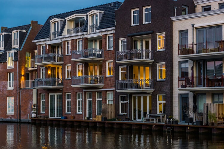 photo of view of beautiful and luxurious terraced houses at the canal, Dutch city architecture by night, Alphen aan den Rijn, The Netherlands.