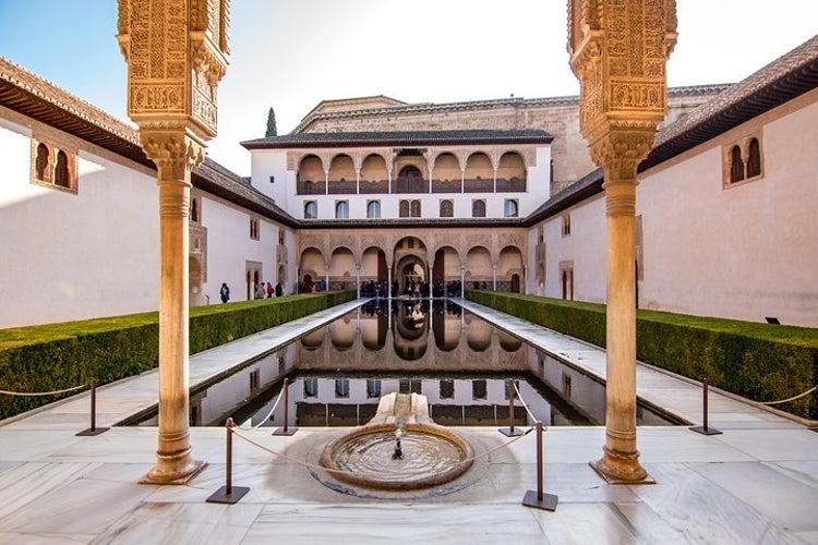 The Court of the Myrtles in the Alhambra, Granada, features a central pool surrounded by arches and columns..jpg