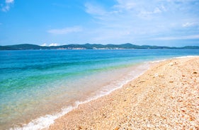 Photo of panorama and landscape of Makarska resort and its harbour with boats and blue sea water, Croatia.