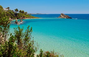 Photo of white boat in crystal clear blue sea water, Argostoli, Greece.