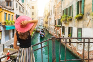 Famous buildings, gondolas and monuments by the Rialto Bridge of Venice on the Grand Canal, Italy.