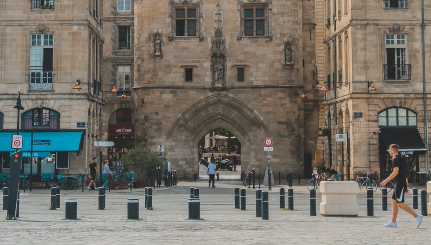 Front view of Porte Cailhau (Cailhau Gate) in Bordeaux, framed by historic buildings and pedestrians..jpg