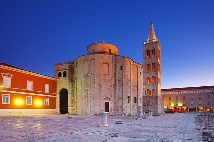 Five Wells Square with ancient stone ruins, a circular church with a bell tower, and another stone church with a tall bell tower nearby..jpg