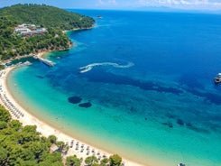 Photo of beautiful aerial view of the old town Skiathos with boats in the harbor, on Skiathos Island, Greece. 