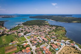 photo of an aerial view of the stunning Croatian coastal town of Pomer, with its picturesque oceanfront buildings and harbor.