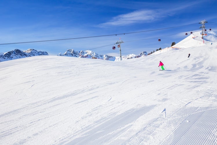 photo of ski slopes with the corduroy pattern and cable car on the top of Fellhorn Ski resort, Bavarian Alps, Oberstdorf, Germany.