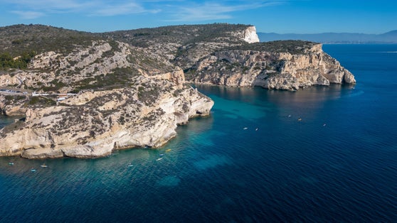 photo of view Aerial view with drone of the Sella del Diavolo in Cagliari. Sunny day, crystal clear sea with boats., Cagliari, Italy.