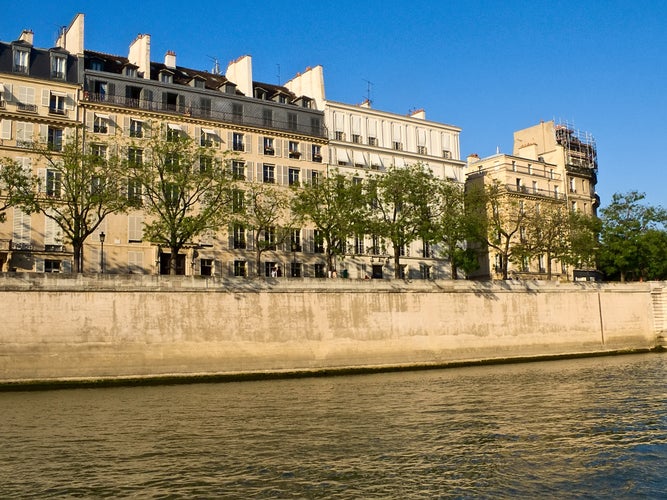 photo off view of View of the Quay de Bethune on the island of Saint-Louis in Paris on a May sunny evening, France.