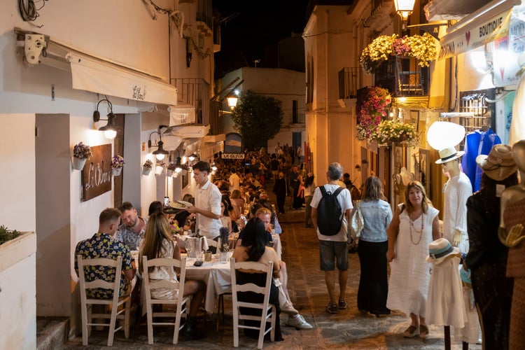 People dine outside in the evening in a narrow street of Dalt Vila.jpg