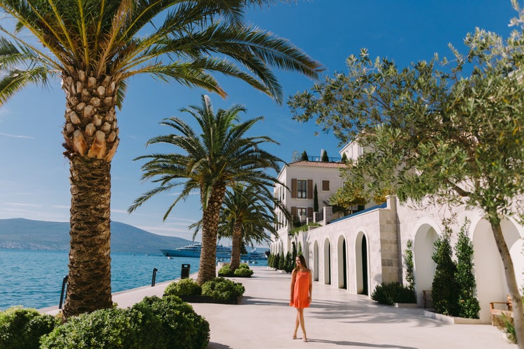 Photo of woman, palm trees and yachts background, Tivat, Montenegro.