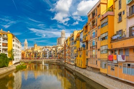 Photo of colorful yellow and orange houses and Eiffel Bridge, Old fish stalls, reflected in water river Onyar, in Girona, Catalonia, Spain.