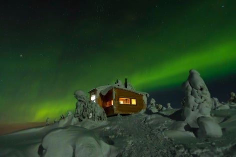 Photo of Chalet in top of Luosto with northern lights, Finland.