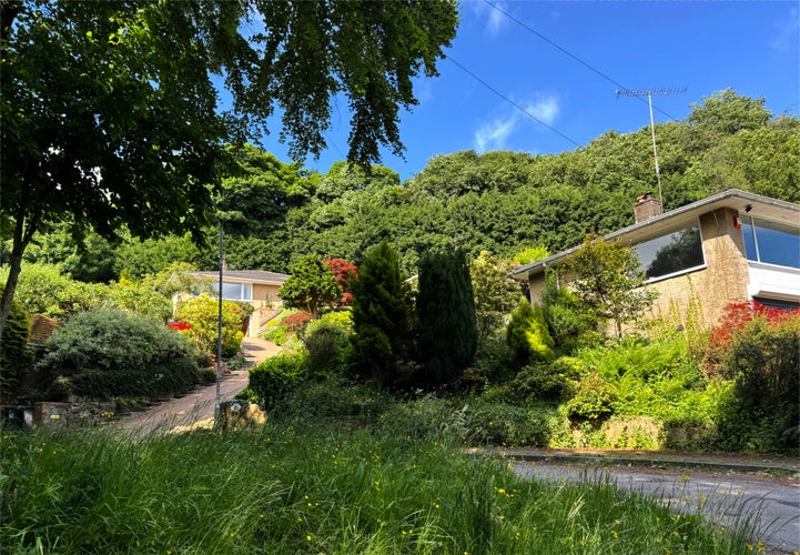 photo of view ofA verdant landscape envelops a residential zone where homes are nestled amidst thick greenery, near Longwood Reservoir in Milnsbridge, Huddersfield, UK.