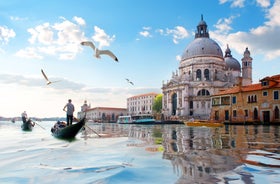 Famous buildings, gondolas and monuments by the Rialto Bridge of Venice on the Grand Canal, Italy.