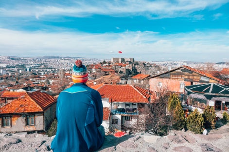 photo of men sitting on the wall looking at Ankara Castle in Altındağ, Ankara, Turkey.