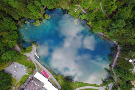 photo of aerial view of Blausee (Blue Lake) a small mountain lake in Kander Valley in Switzerland.