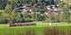 photo of Pinzgauer Lokalbahn a train passing through Austrian countryside next to a village.